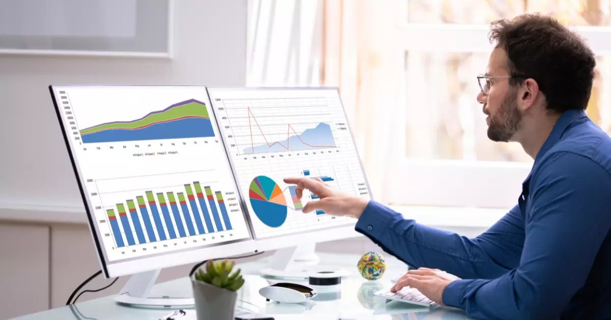 A person pointing at a graph on a computer