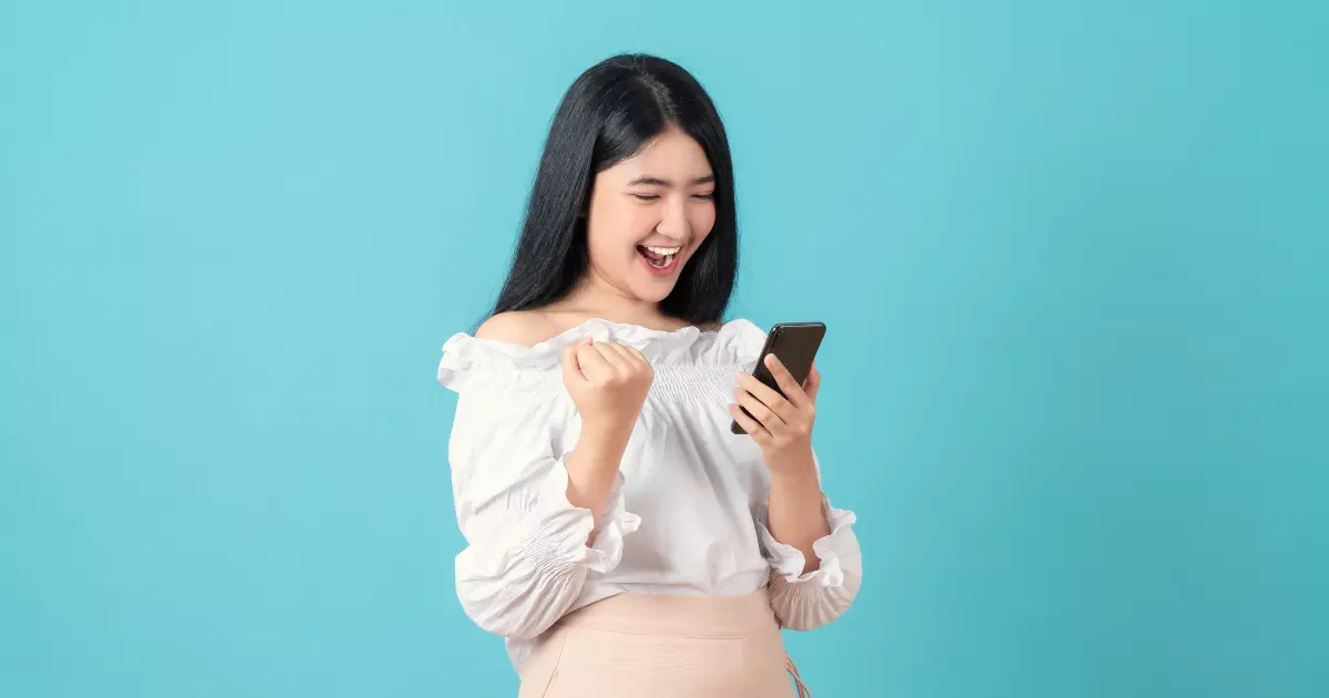 A person holding a phone and cheering