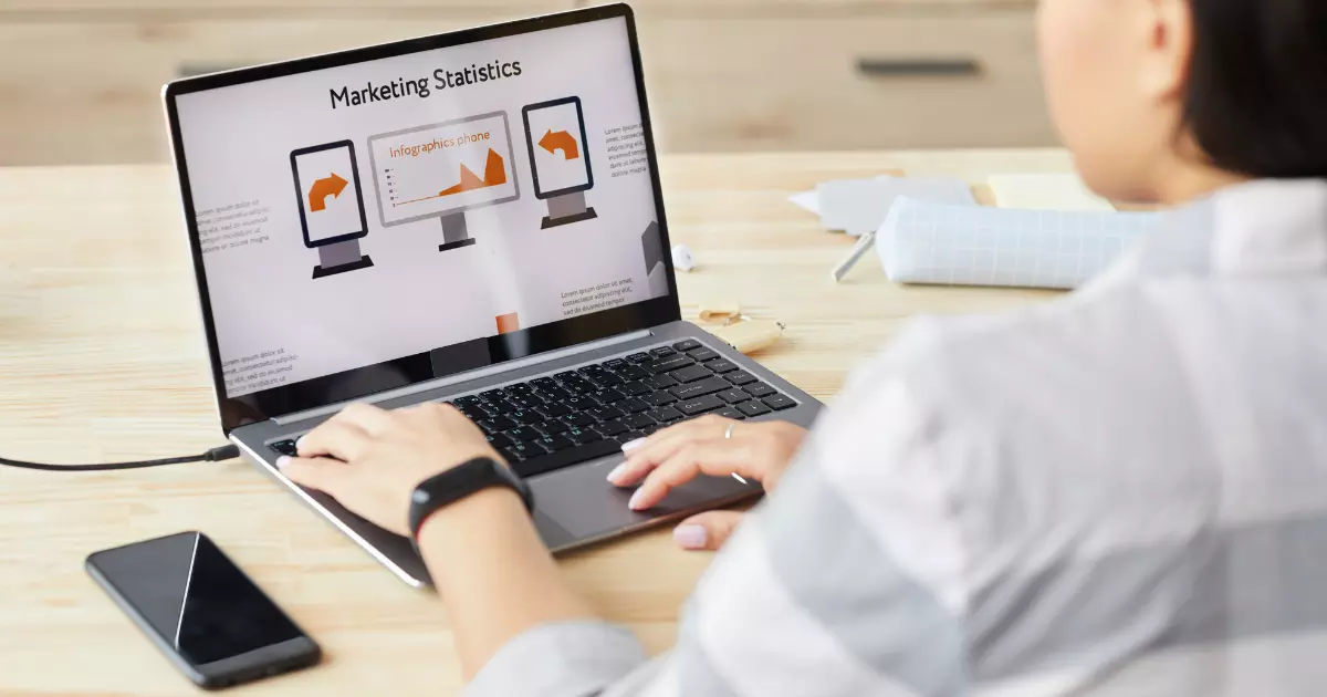 A person looking at marketing statistics on a laptop