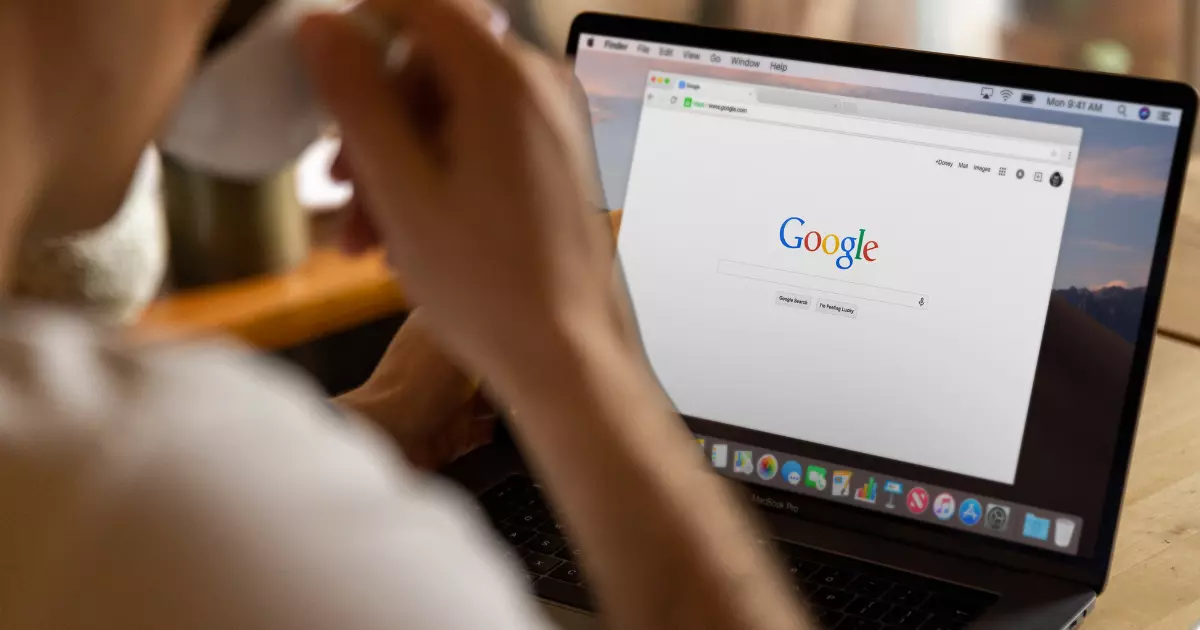 A person searching on Google using a laptop