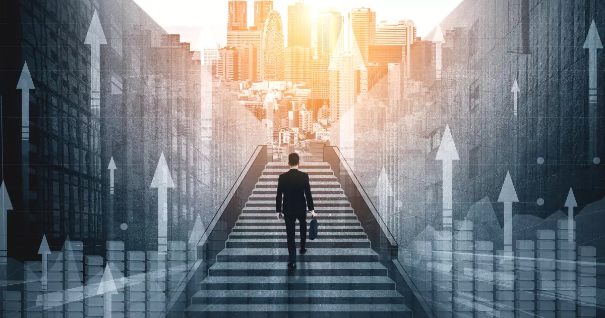 A businessman walking up a staircase towards a bright city skyline symbolizing organic growth and business success