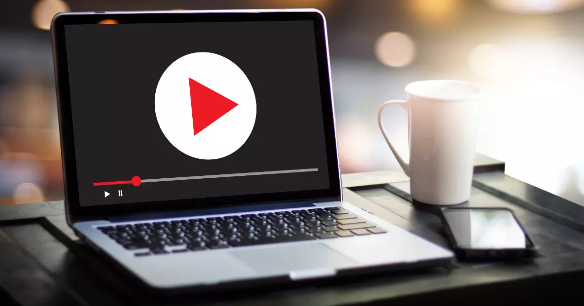 A laptop screen displaying a video play button representing digital content and the power of video marketing